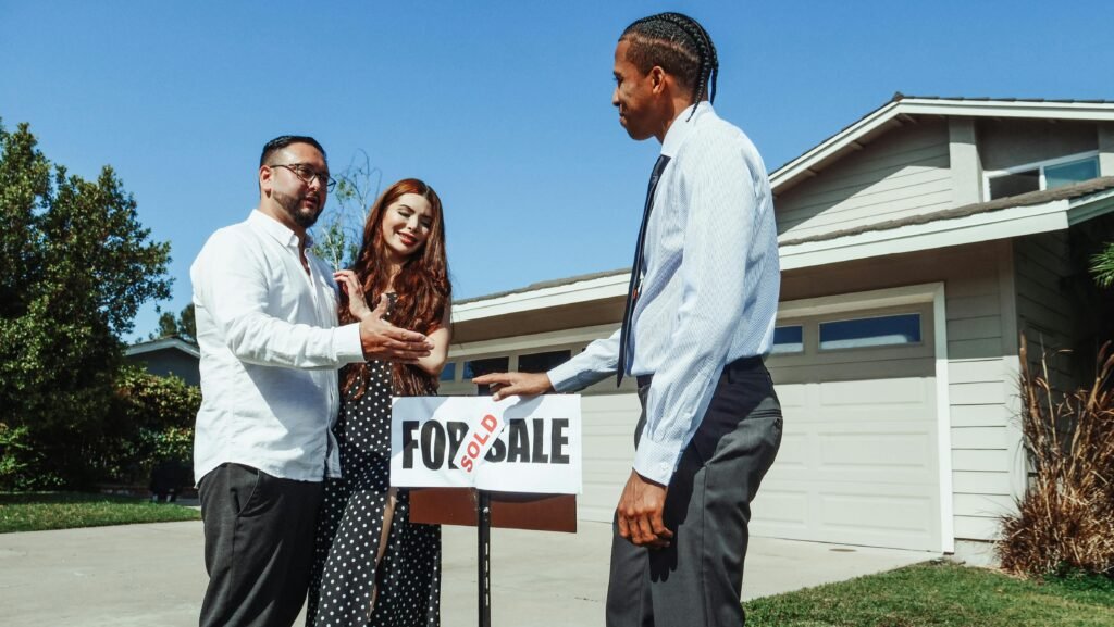 pexels-photo-7578905-7578905 A couple meets with a realtor to finalize the purchase of their new home, indicated by a 'Sold' sign.